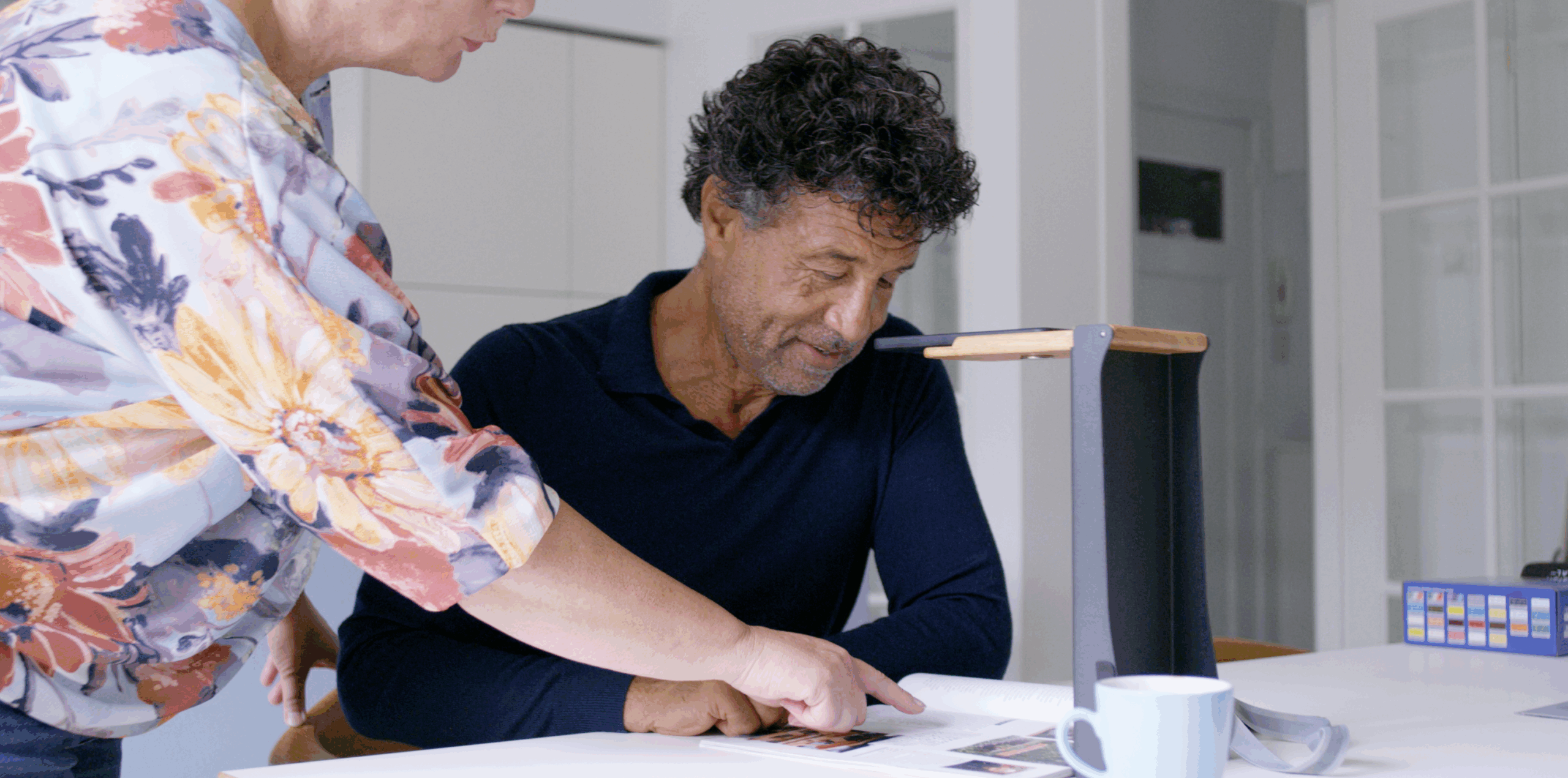 Man gebruikt hulpmiddelen voor slechtzienden, ondersteund door assistent.